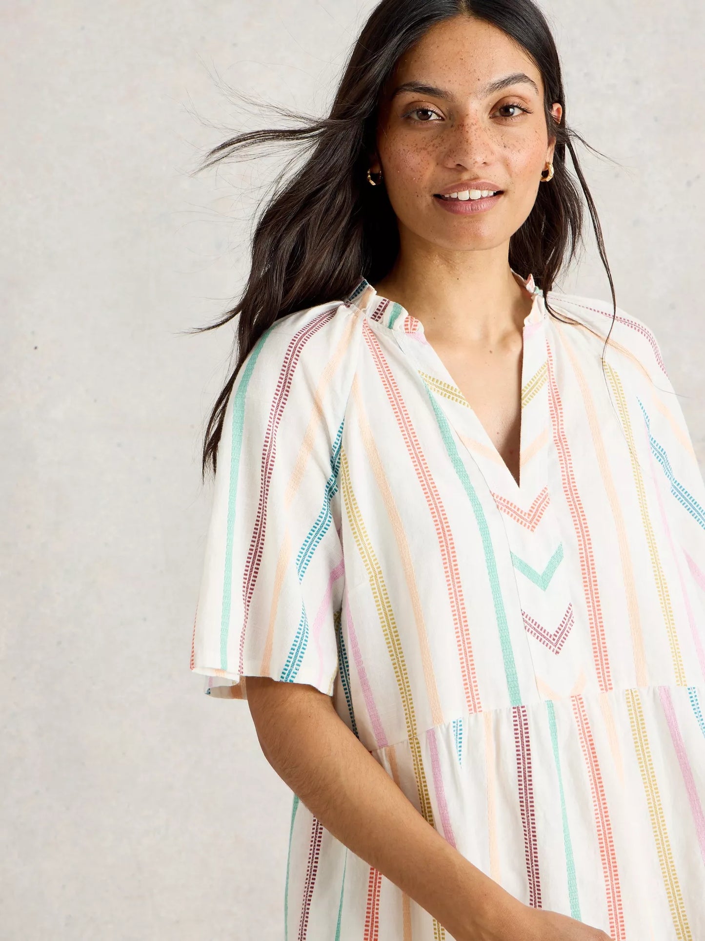 the Sophia Stripe Dress, a 100% organic cotton dress from White Stuff. This elegant dress boasts short sleeves, a notch neck, and a lovely tiered skirt. The dress is white with stunning colorful stripes to add a pop of colour to your wardrobe.