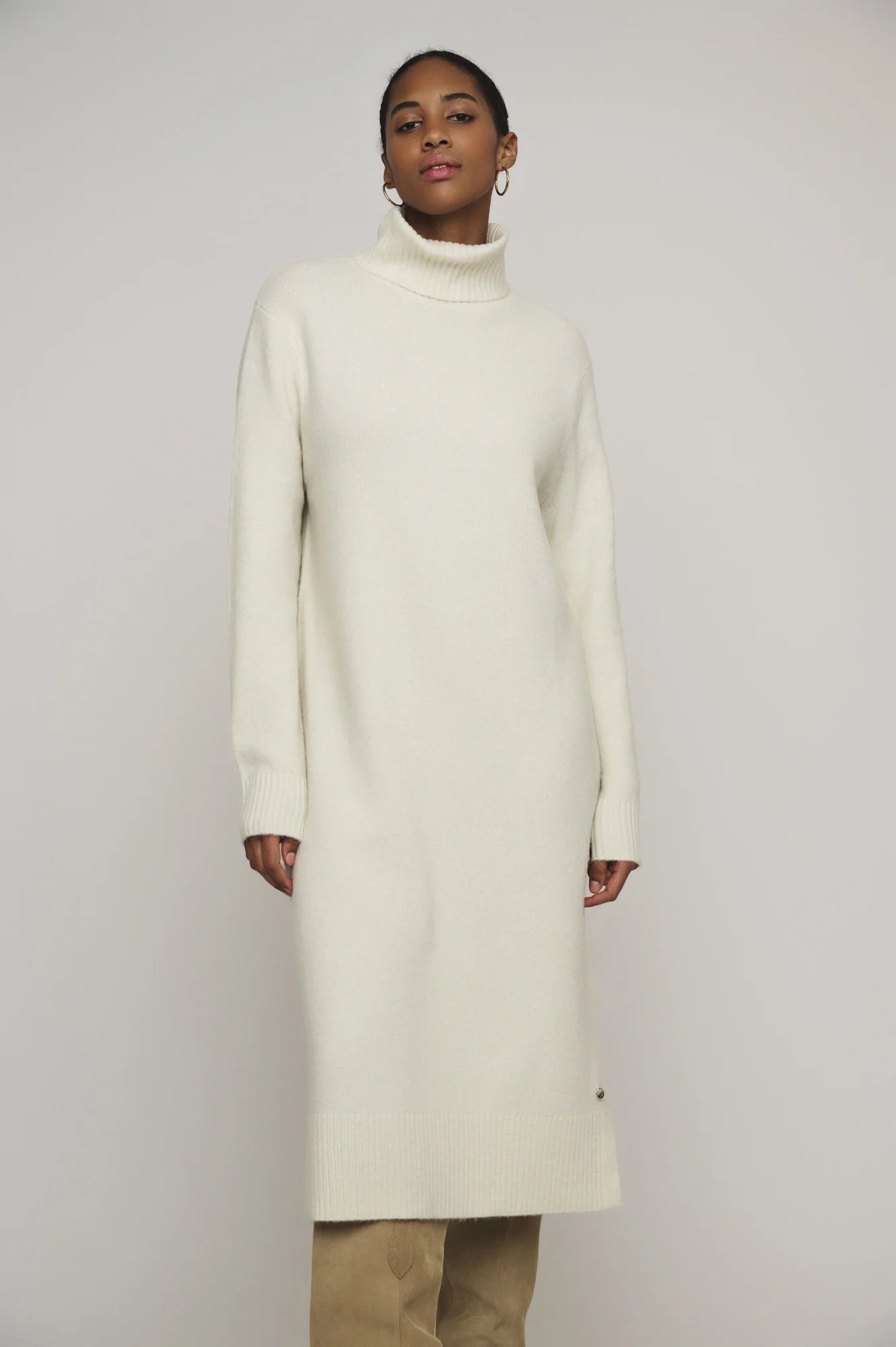 Snuggle up in this knit ivory Tenzil dress from Rino & Pelle for a playful turtleneck, ribbed details, cool side slits, and ultimate comfort. Add some knee high boots and you're ready to hit the town!