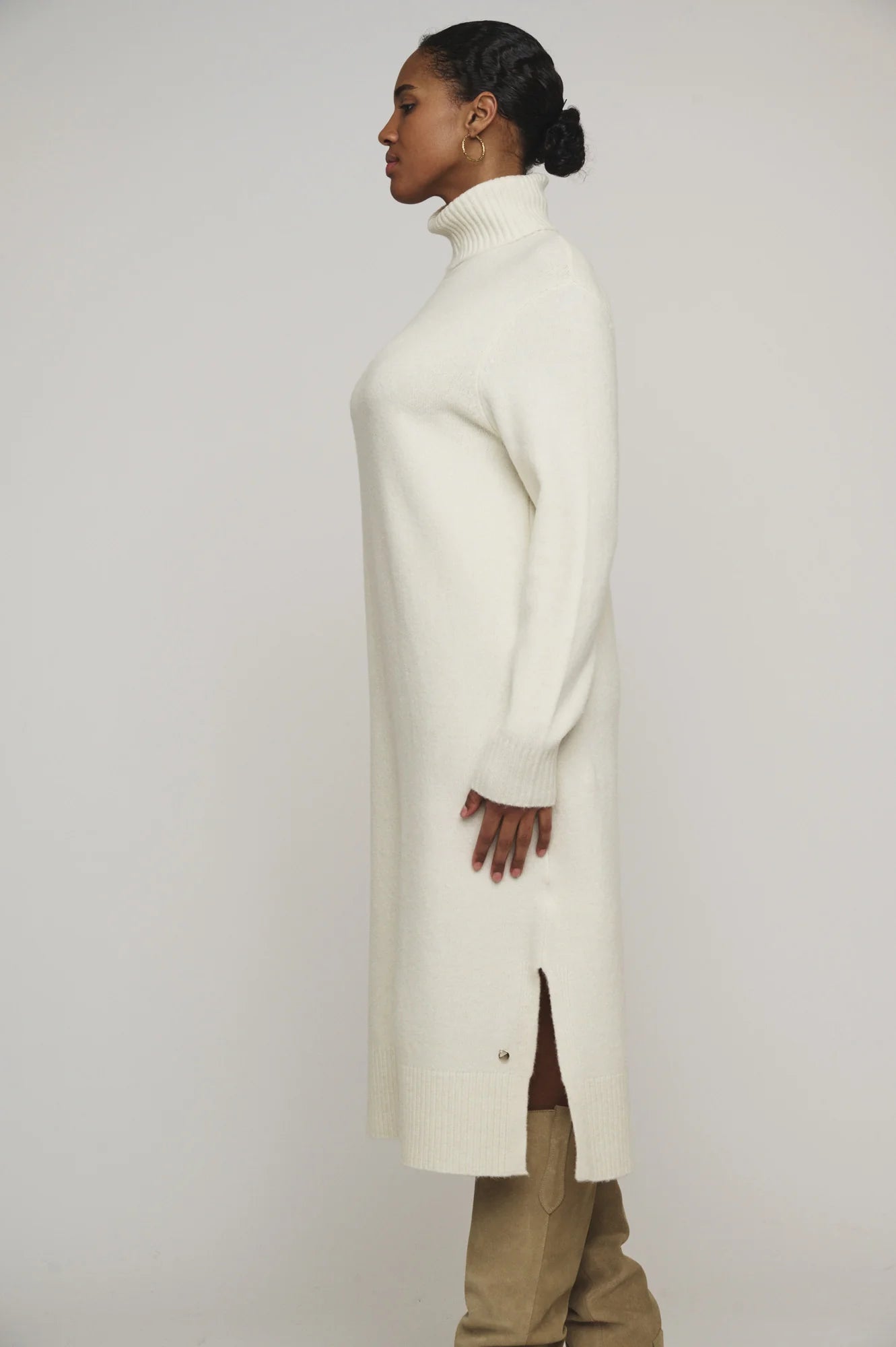 Snuggle up in this knit ivory Tenzil dress from Rino & Pelle for a playful turtleneck, ribbed details, cool side slits, and ultimate comfort. Add some knee high boots and you're ready to hit the town!