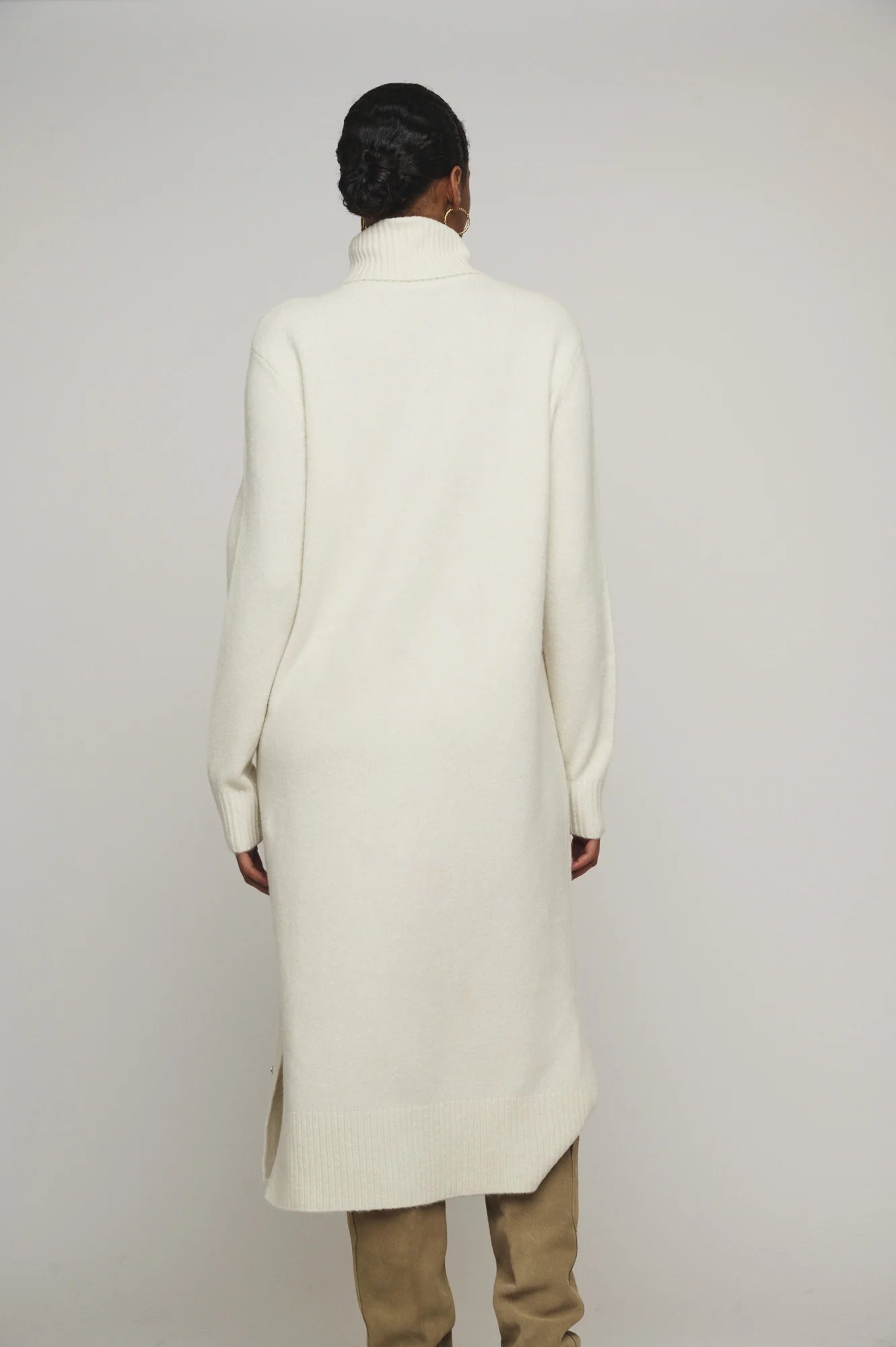 Snuggle up in this knit ivory Tenzil dress from Rino & Pelle for a playful turtleneck, ribbed details, cool side slits, and ultimate comfort. Add some knee high boots and you're ready to hit the town!