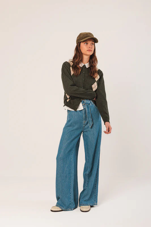 Person wearing a green jacket, white shirt, and blue jeans on a white background