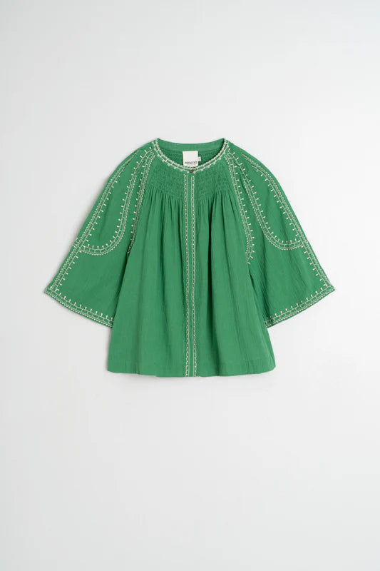 Green dress with embroidered details on a white background