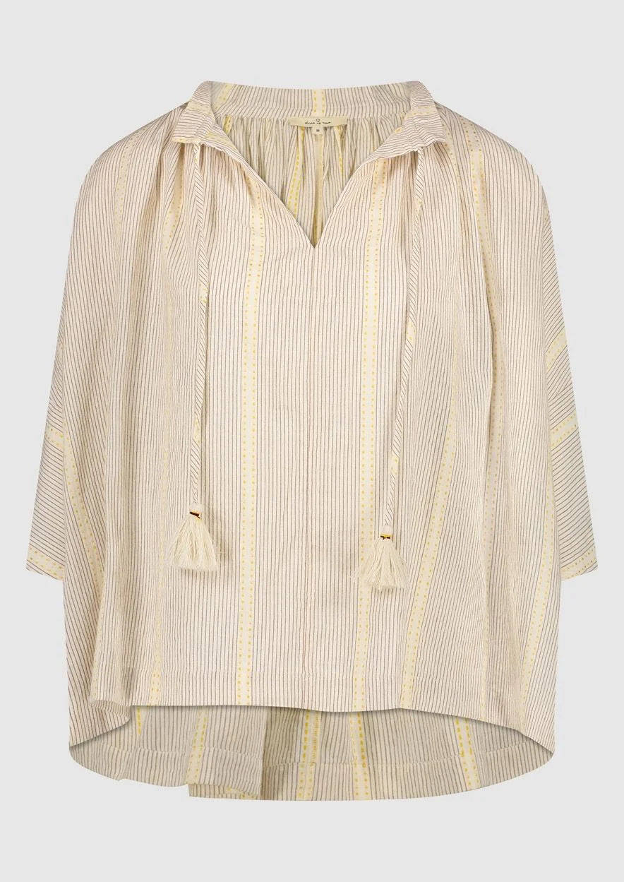 Introducing the Avril Blouse in Antique White by Circle of Trust. Made from soft 100% cotton, it's comfy and breathable for everyday wear. The loose fit and vertical stripe pattern give it a relaxed yet stylish vibe. With a V-neck and delicate strings, it's effortlessly charming. Plus, it has drop shoulders and wide sleeves for a comfy fit. Finished with tassel ties and subtle ochre accents, it's a versatile piece for any occasion. Pair it with denim shorts or a skirt for a casual look. 