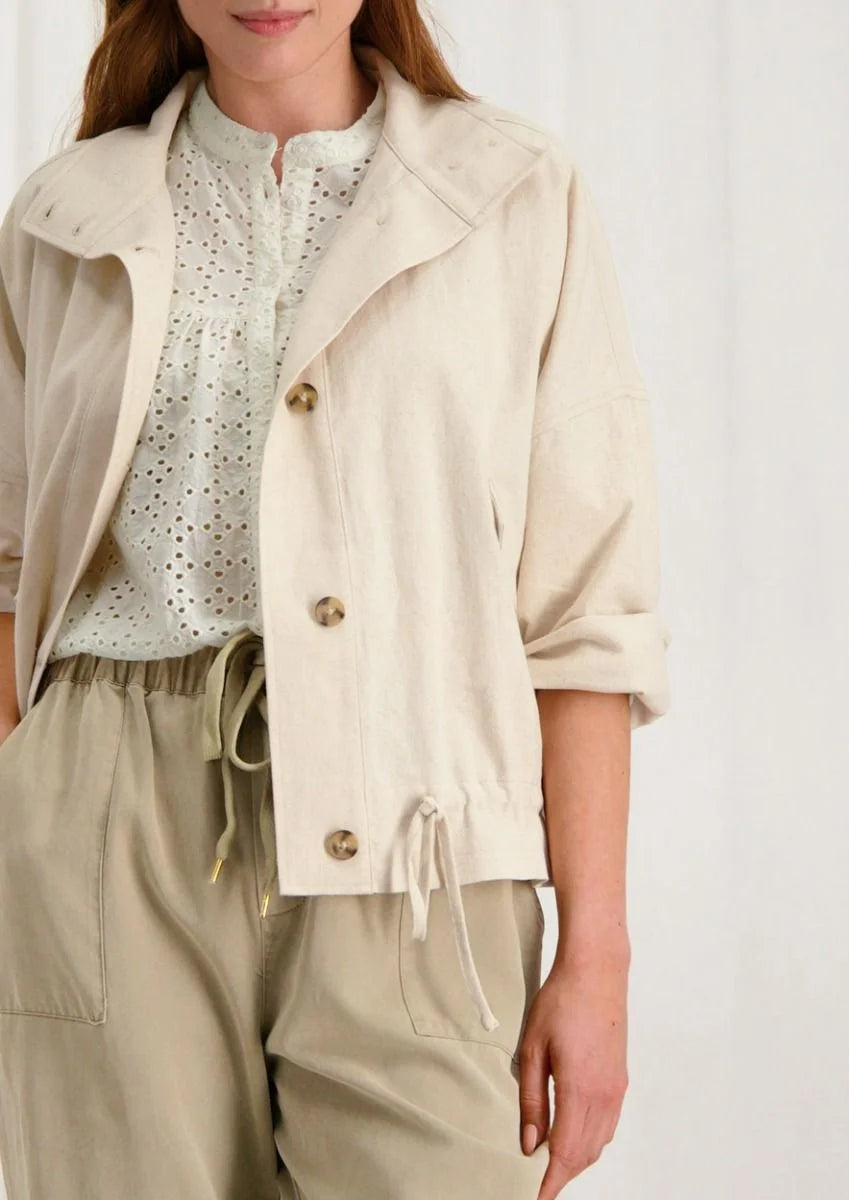 Introducing the Bibi Jacket by Circle of Trust. Made with a blend of linen and cotton, it's lightweight and comfy in a beautiful vanilla colour. With its loose fit and button-down front, it's easy to wear and style. The jacket has flap pockets and unique bat sleeves. Perfect for casual days out or running errands, or dress it up. It's a versatile addition to your wardrobe.