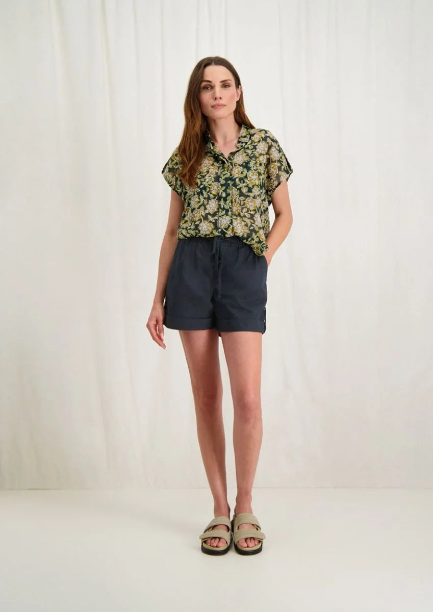 Introducing Circle of Trust's Mali Shorts in India Ink. Made of 100% cotton, these shorts are both comfy and stylish. They feature a loose fit, buttoned accents, an elastic waistband with a drawstring, and slit pockets for convenience. Perfect for any casual outing, these shorts offer comfort and versatility.