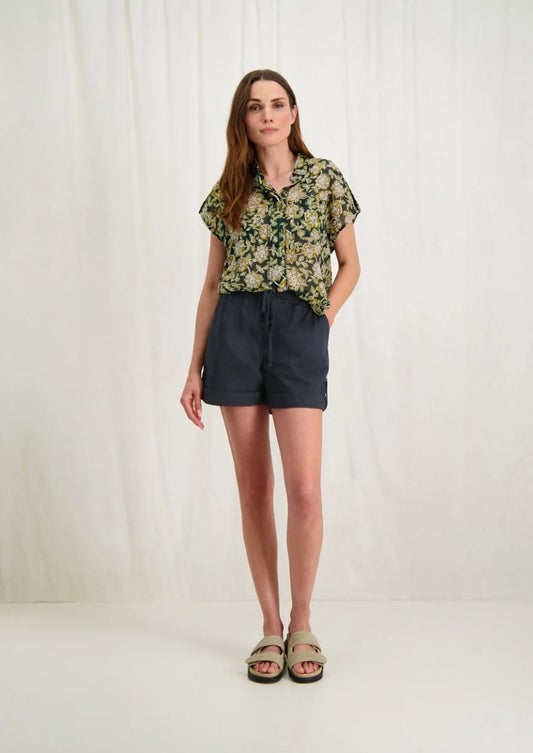 Introducing Circle of Trust's Mali Shorts in India Ink. Made of 100% cotton, these shorts are both comfy and stylish. They feature a loose fit, buttoned accents, an elastic waistband with a drawstring, and slit pockets for convenience. Perfect for any casual outing, these shorts offer comfort and versatility.