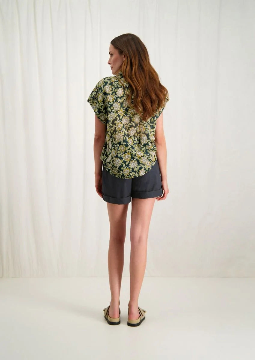 Introducing Circle of Trust's Mali Shorts in India Ink. Made of 100% cotton, these shorts are both comfy and stylish. They feature a loose fit, buttoned accents, an elastic waistband with a drawstring, and slit pockets for convenience. Perfect for any casual outing, these shorts offer comfort and versatility.