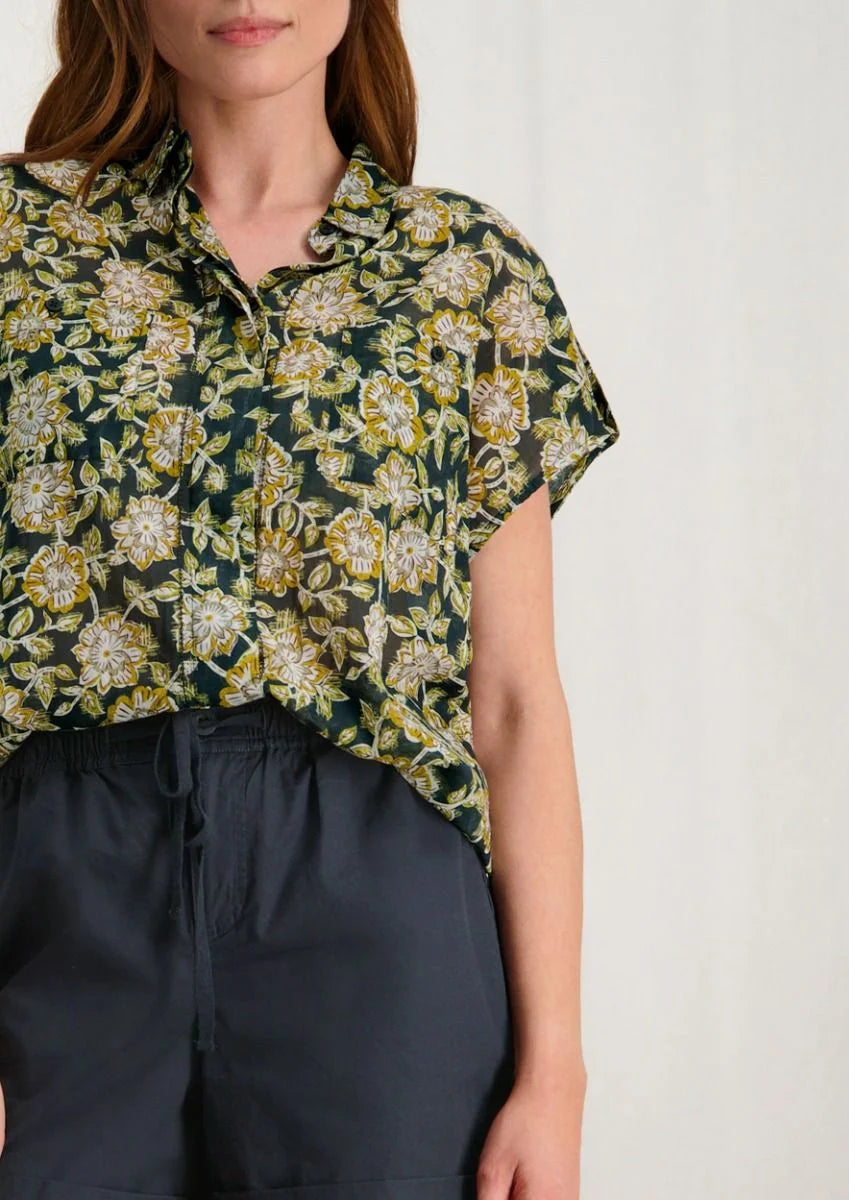 Introducing Circle of Trust's Mali Shorts in India Ink. Made of 100% cotton, these shorts are both comfy and stylish. They feature a loose fit, buttoned accents, an elastic waistband with a drawstring, and slit pockets for convenience. Perfect for any casual outing, these shorts offer comfort and versatility.