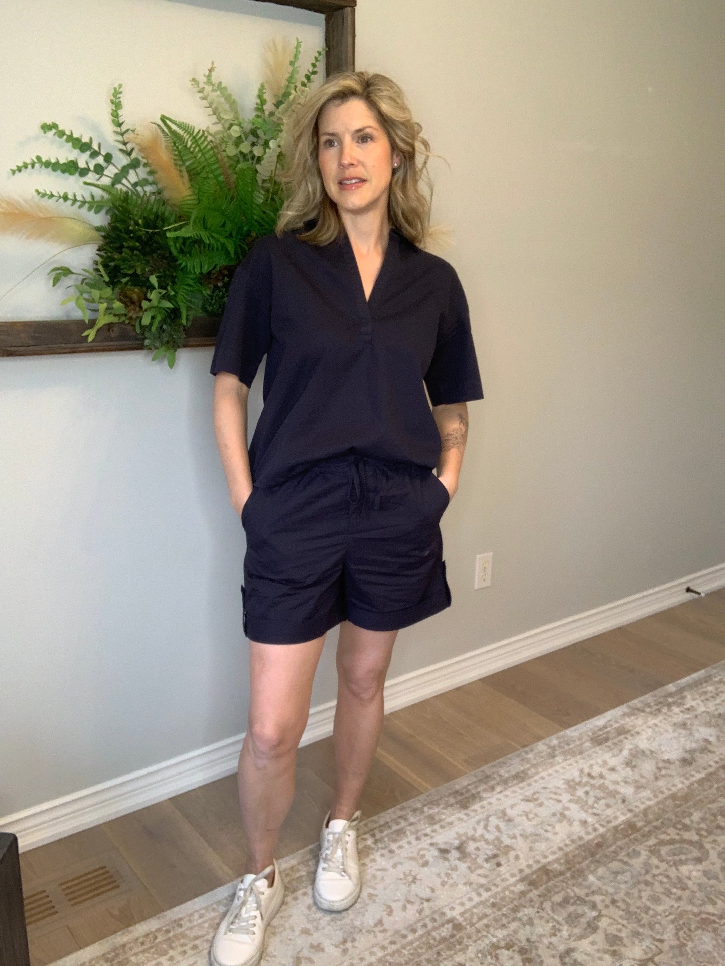Introducing Circle of Trust's Mali Shorts in India Ink. Made of 100% cotton, these shorts are both comfy and stylish. They feature a loose fit, buttoned accents, an elastic waistband with a drawstring, and slit pockets for convenience. Perfect for any casual outing, these shorts offer comfort and versatility.