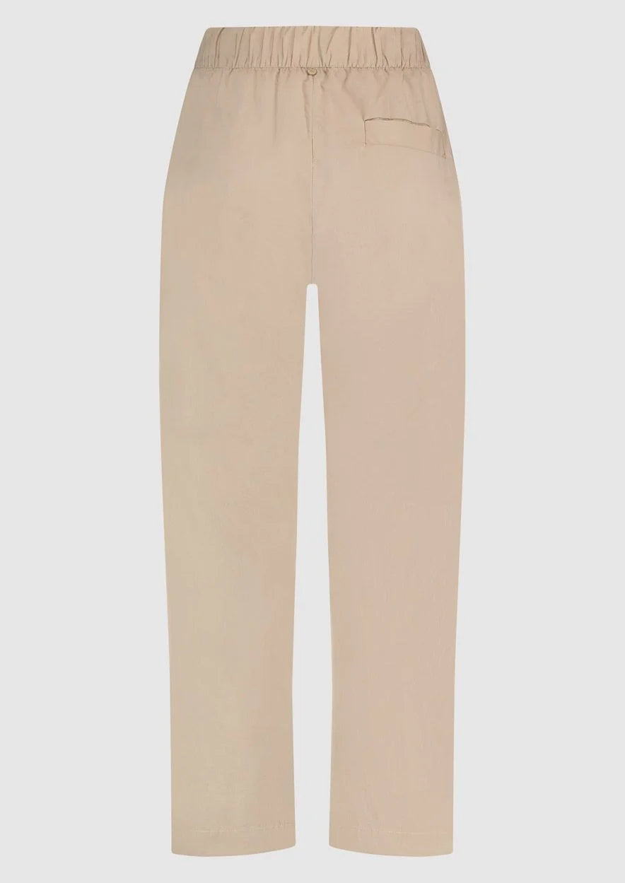 Discover comfort and style with our Millie Cotton Women's Trousers by Circle of Trust, crafted from soft cotton fabric in a chic light coffee hue. These pants feature a flattering straight fit and are equipped with a convenient elastic waistband for ease of wear. Complete with practical side pockets, they are perfect for effortless everyday elegance. Roll them up for a more casual look.