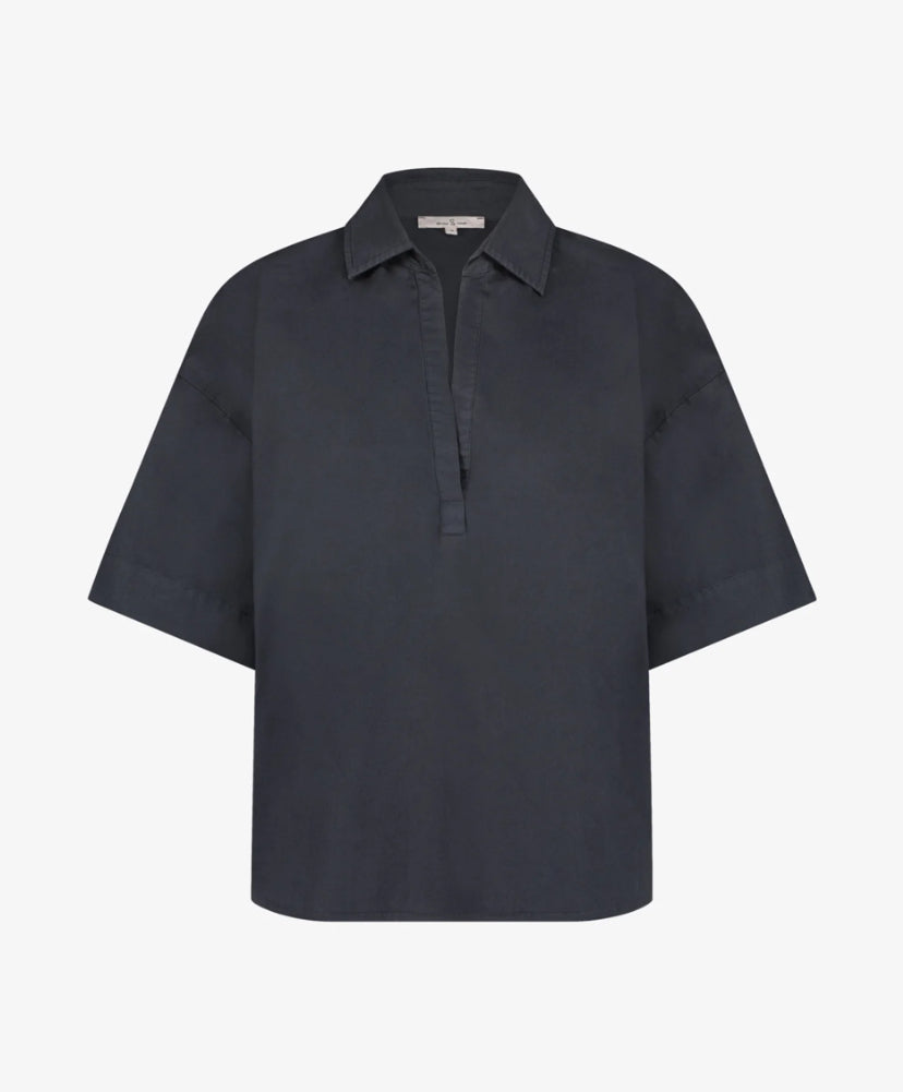 Introducing the effortlessly chic Ovi Blouse in India Ink by Circle of Trust, a wardrobe essential crafted from 100% cotton for unparalleled comfort and breathability. Embrace relaxed elegance with its oversized silhouette, exuding contemporary charm with every wear. This versatile piece features a flattering V-neckline and short sleeves, all tailored to perfection in soft, luxurious cotton. Elevate your ensemble with the understated sophistication of the Ovi Blouse, a timeless addition to your collection.