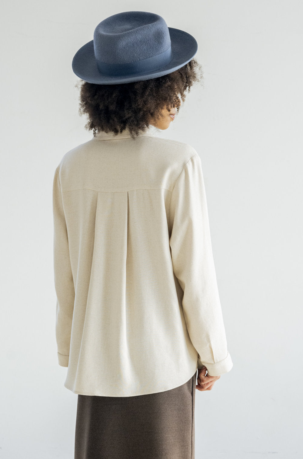 Effortlessly stylish and always on trend. Featuring a twist on the classic button-down style, the Douglas Top in a beautiful vanilla colour is a versatile addition to your wardrobe. Complete with our signature square matte metal buttons, one front pocket and a pleated back. This shirt is a must-have for any fashion-forward individual.