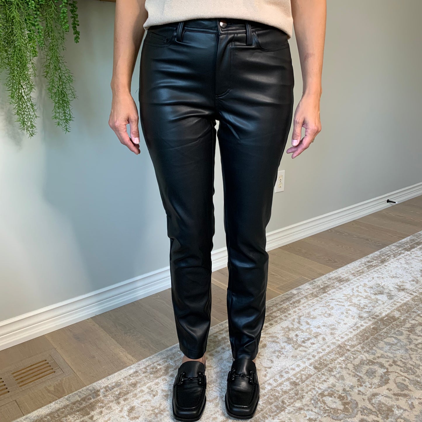 Crafted from top-notch black fake leather for a comfy-cool appearance. With the feel of real lambs skin, these five pocketed pants offer a trendy, chill vibe to any ensemble.