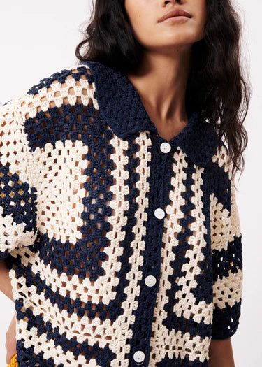 This Pilar Crochet Cardiganin cream and navy from FRNCH is perfect for creating a stylish summer look. Pair it with a colorful bag and comfortable flat shoes for a complete outfit. With button tabs and short, loose sleeves, this crochet shirt offers both style and freedom of movement in a straight cut design. Wear it open with a graphic tee or closed for a different look.