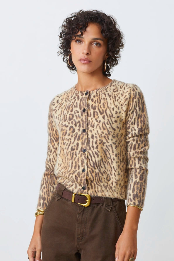Woman wearing a leopard print top and brown pants on a white background