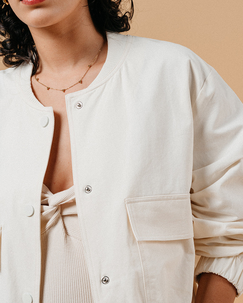 Introducing the silhouette: Bomber jackets have evolved into a cult favorite and an essential in every woman's wardrobe, especially this season. Explore our feminine and elegant take on the classic bomber: MEGANE, crafted from 100% cotton, ensuring versatility across all seasons in it's warm whate ecru colour. This cropped bomber is an absolute standout, effortlessly pairing with both pumps and sneakers alike.