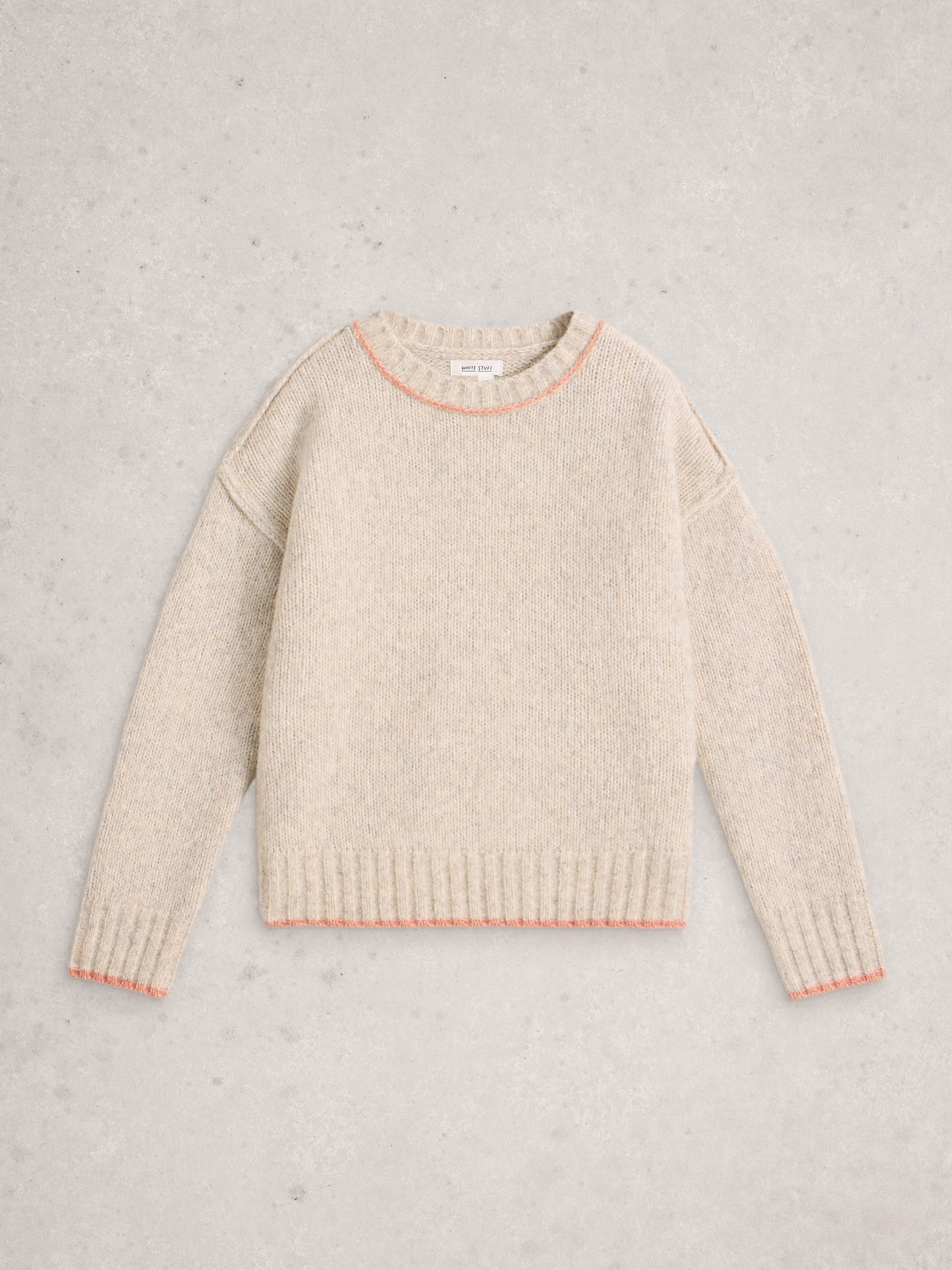 Beige sweater with pink trim on a light gray background