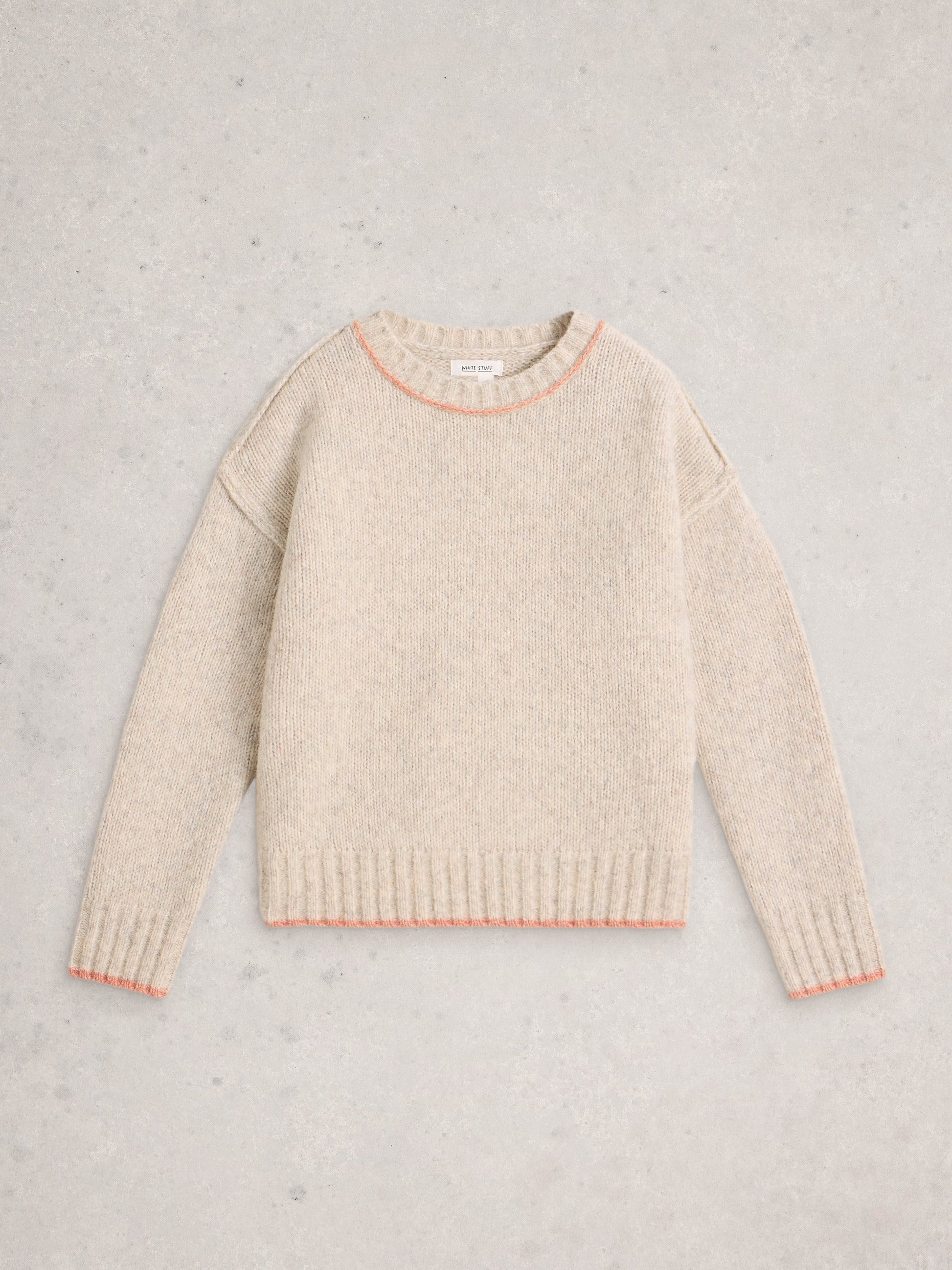 Beige sweater with pink trim on a light gray background