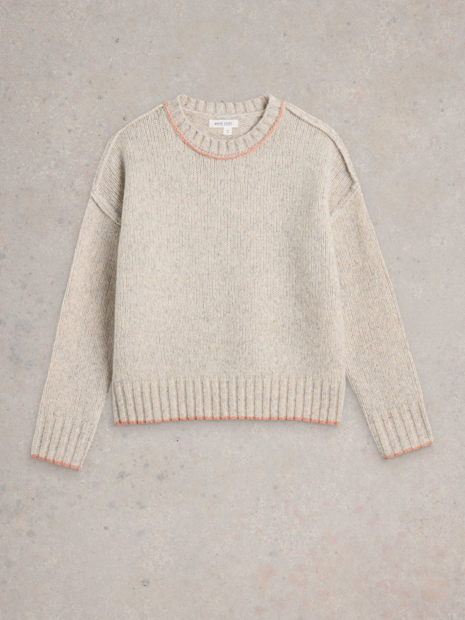 Beige sweater with pink trim on a gray background