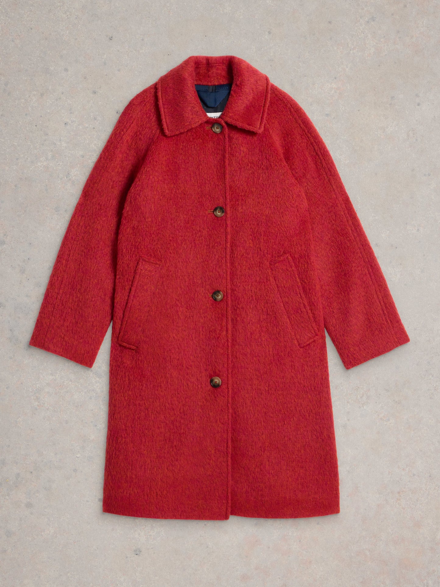 Red coat with buttons on a beige background