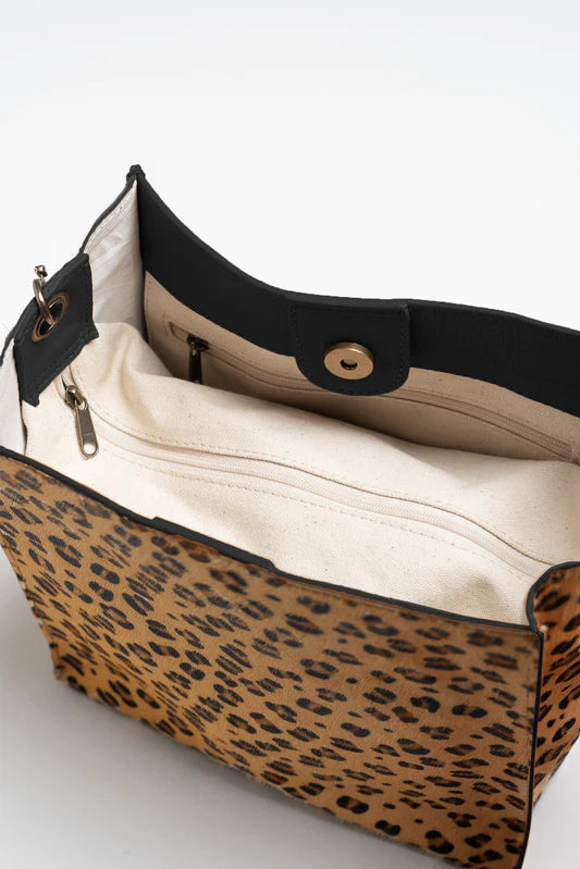 Leopard print handbag with black trim on a white background