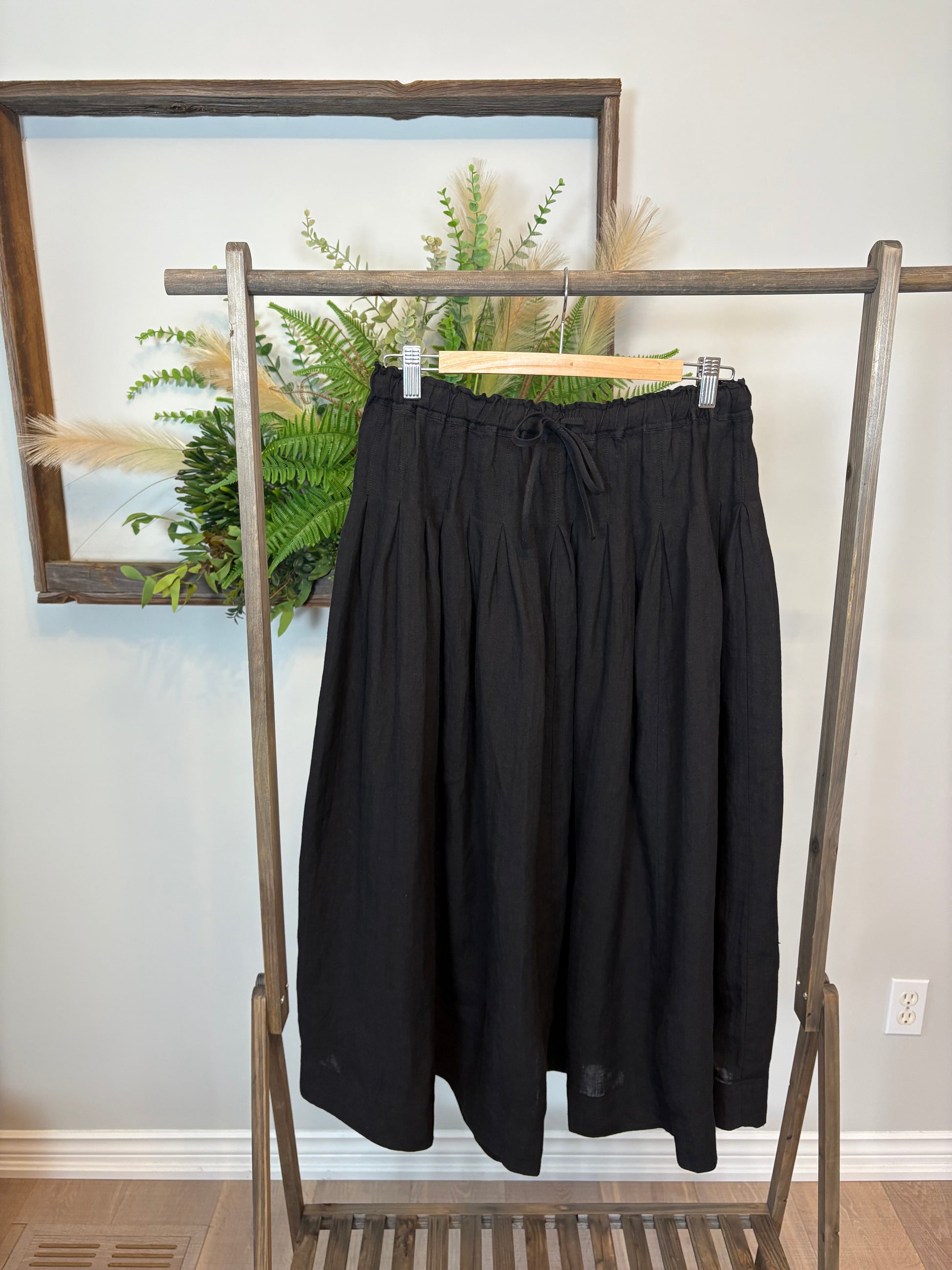 Get ready for some serious twirl action in the Jonie Skirt by Naif. Made from 100% linen, this black full skirt features an elastic waist with a tie front, creating the perfect fit. The beautiful pleating detail adds a touch of elegance to this playful piece.
