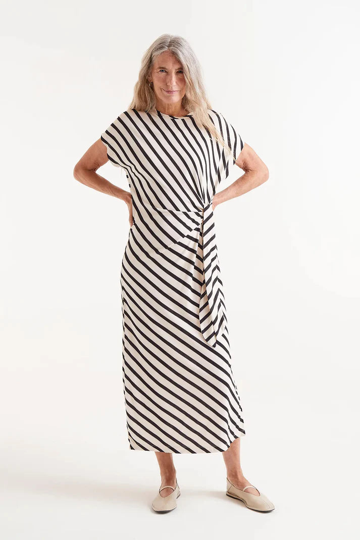 Featuring bold black and beige stripes in Compania Fantastica's signature angled Piano print, this dress brings a playful twist to a timeless silhouette. The round neckline and sleeveless cut make it effortlessly versatile, while the woven front belt adds an eye-catching detail.