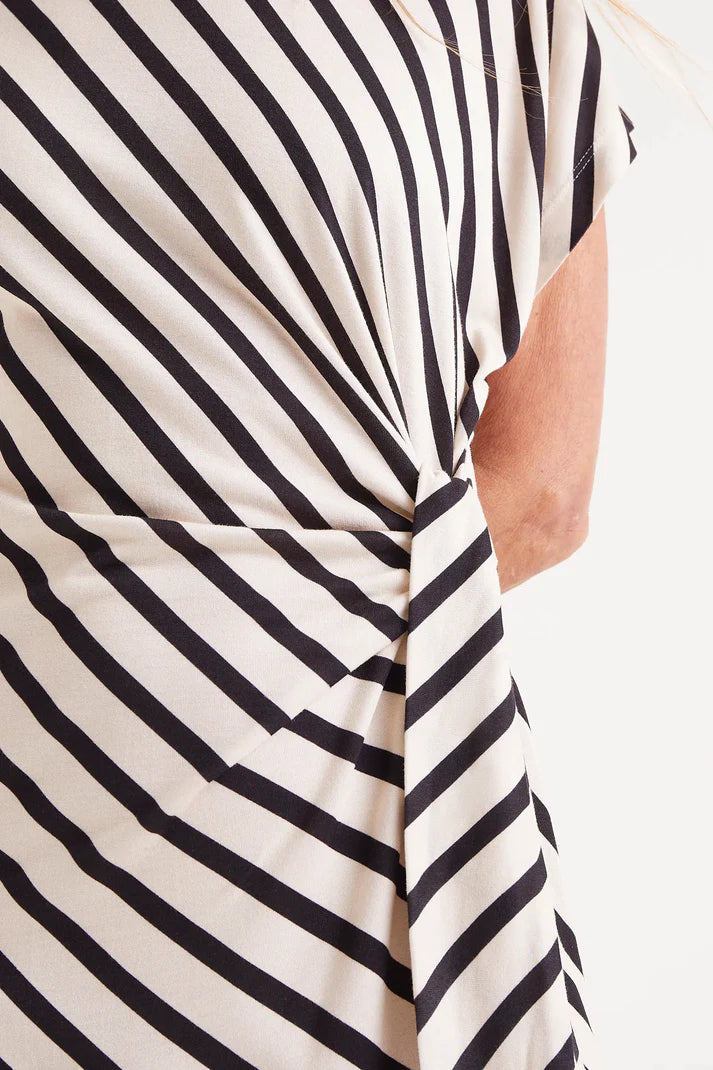 Featuring bold black and beige stripes in Compania Fantastica's signature angled Piano print, this dress brings a playful twist to a timeless silhouette. The round neckline and sleeveless cut make it effortlessly versatile, while the woven front belt adds an eye-catching detail.