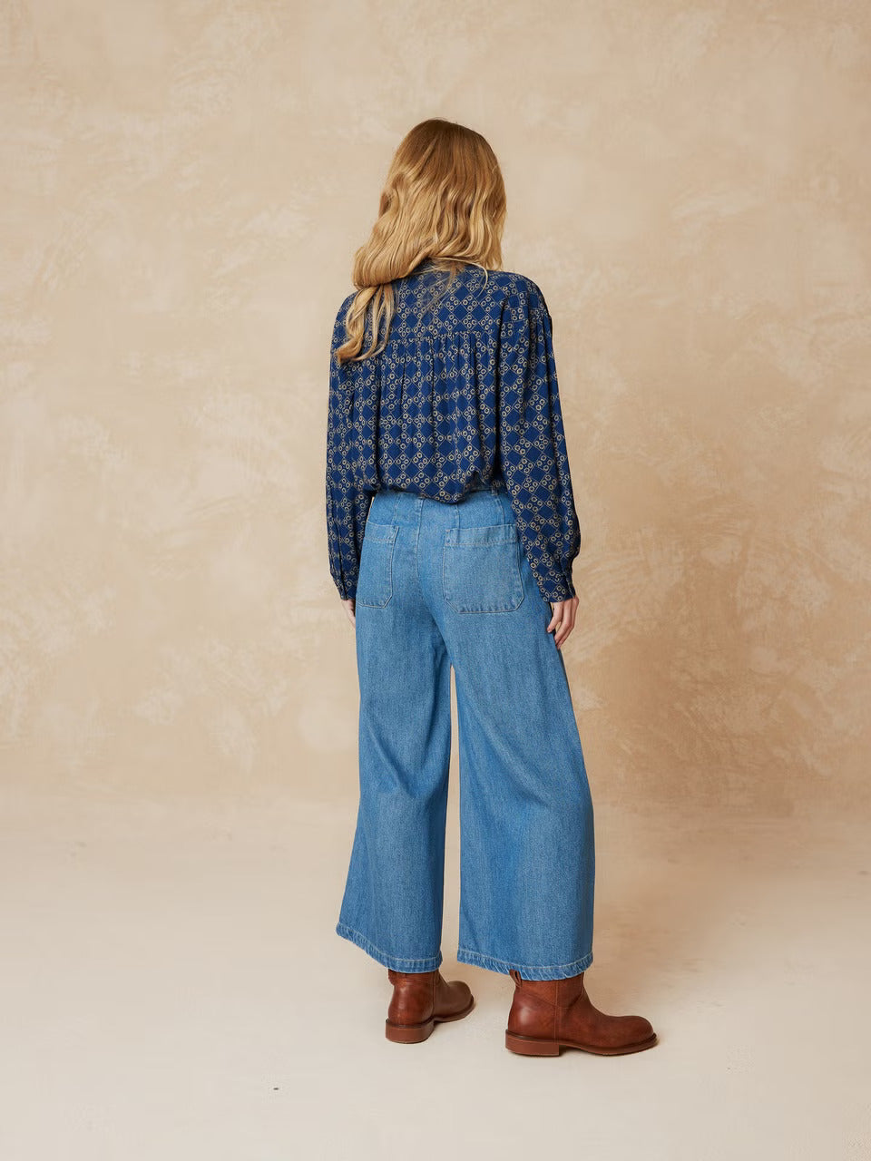 Get ready to turn some heads in our Smoke Detail Blouse by Indi & Cold! Made with soft woven viscose in a beautiful denim blue colour, this blouse features a unique beige geometric pattern and a flattering double button-down front. The rouched detailing across the chest and back adds a touch of fun and playfulness to your outfit. Easy to dress up or down, this is a must-have addition to your wardrobe!