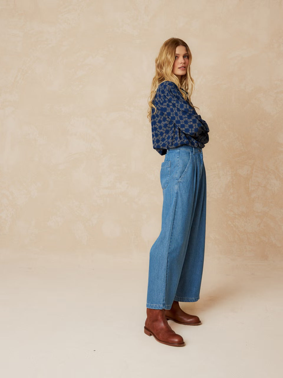Get ready to turn some heads in our Smoke Detail Blouse by Indi & Cold! Made with soft woven viscose in a beautiful denim blue colour, this blouse features a unique beige geometric pattern and a flattering double button-down front. The rouched detailing across the chest and back adds a touch of fun and playfulness to your outfit. Easy to dress up or down, this is a must-have addition to your wardrobe!