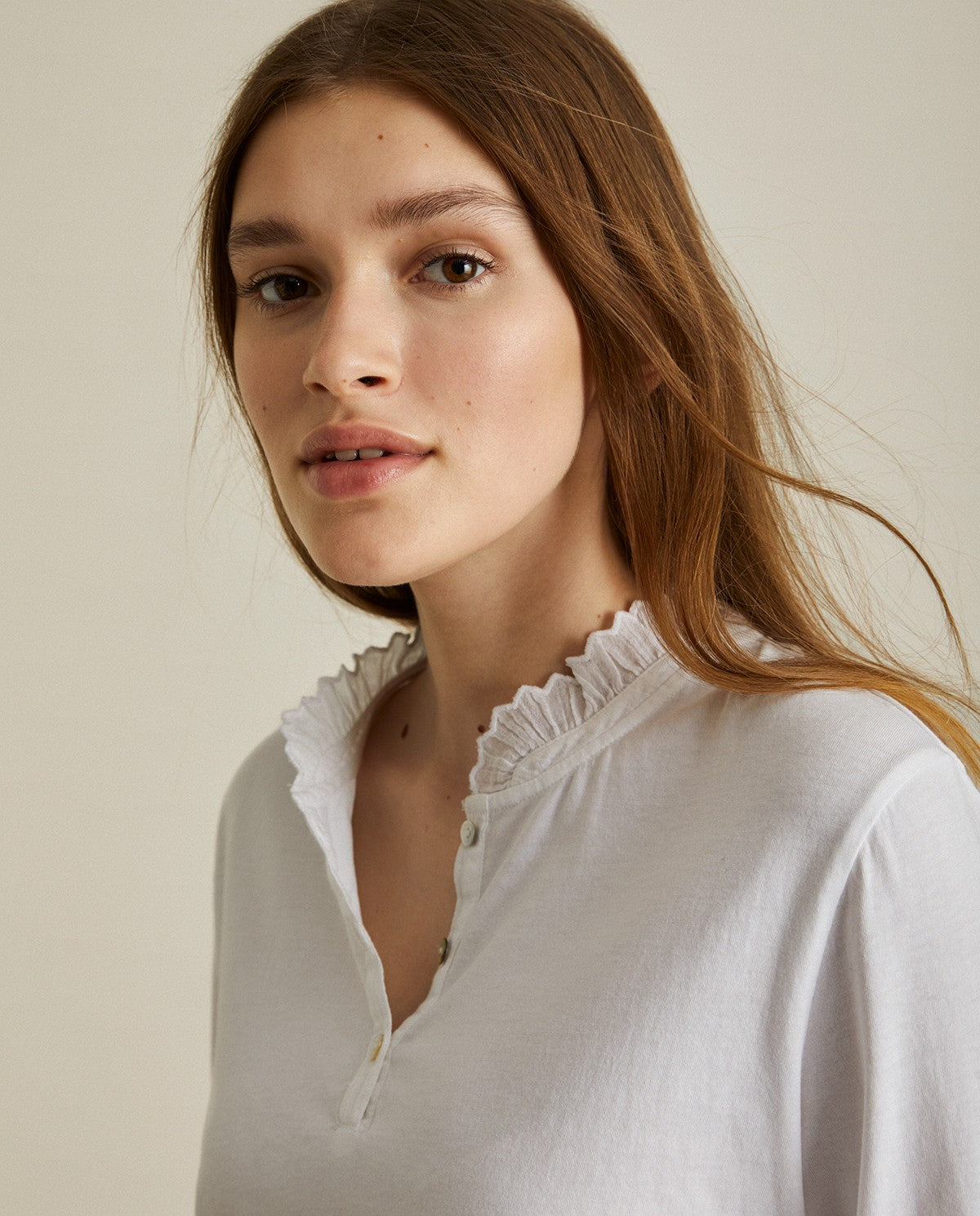 Cotton white shirt with long sleeves and embroidered neck. Decorative stitching on the sleeves and neck.