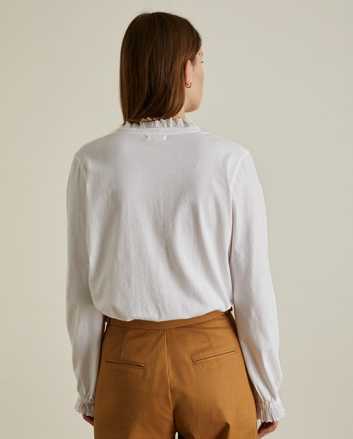 Cotton white shirt with long sleeves and embroidered neck. Decorative stitching on the sleeves and neck.