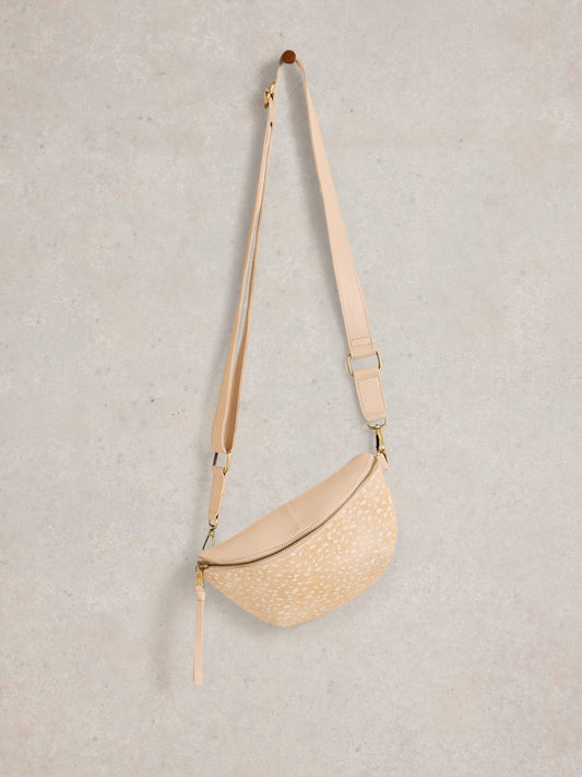 Beige woven crossbody bag on a light gray background