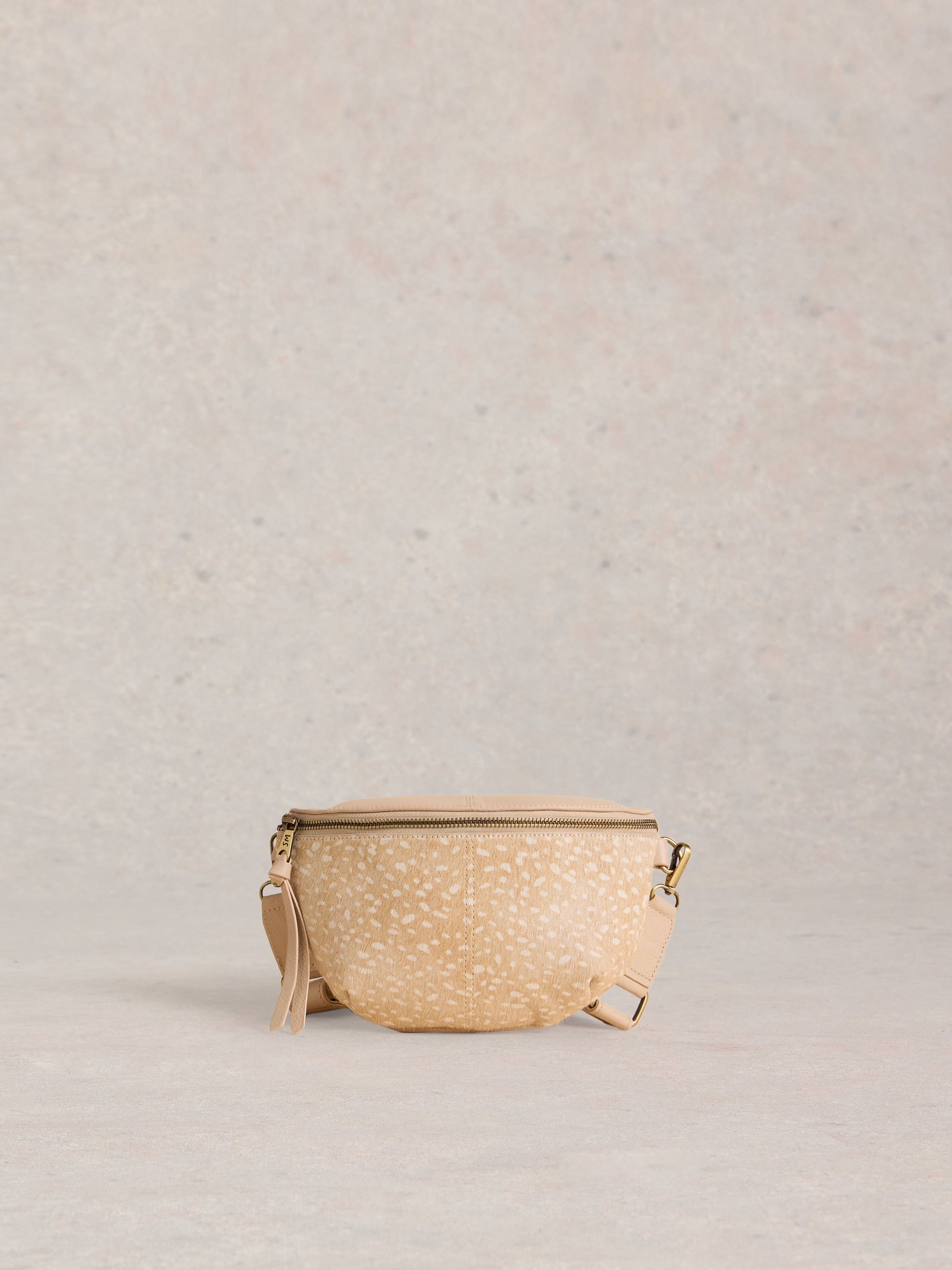 Beige woven bag with a strap on a light gray background