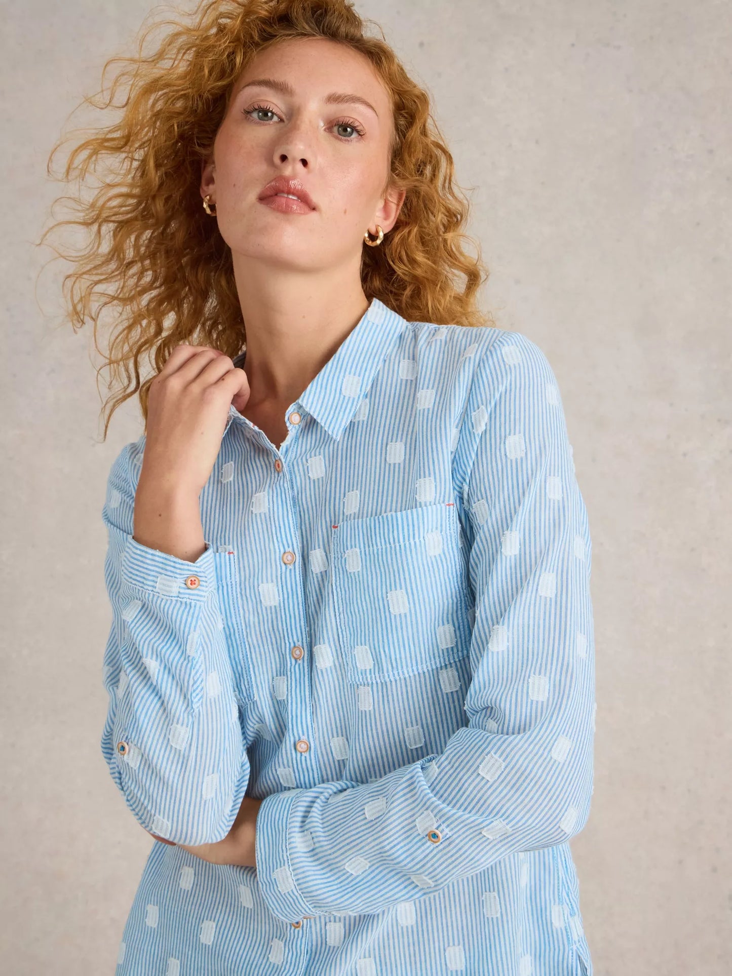 Update your button-up style with Sophie Organic Cotton Shirt - Light Blue Stripes - a playful twist on the traditional white shirt. With a combination of blue stripes and white squares, it's a statement-making piece that will elevate your wardrobe instantly. Trust us, you won't be able to pass up this charming print!