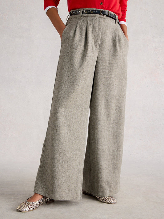 Person wearing gray wide-leg pants with a red top on a light background