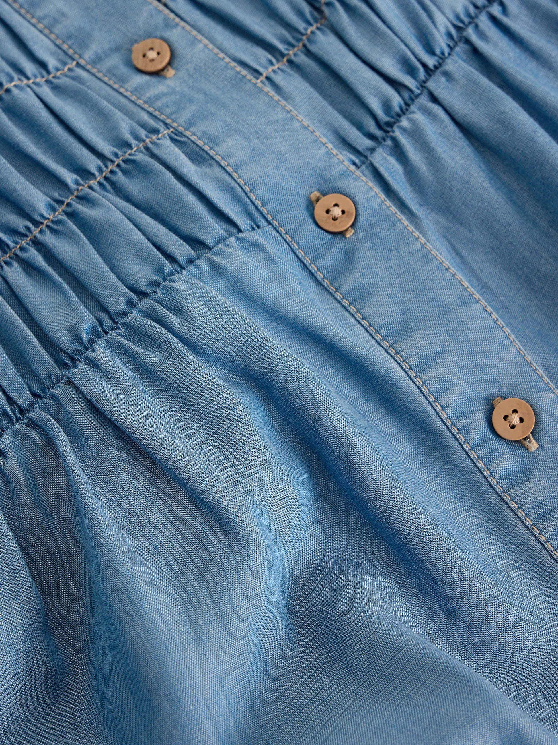 Close-up of blue denim fabric with buttons