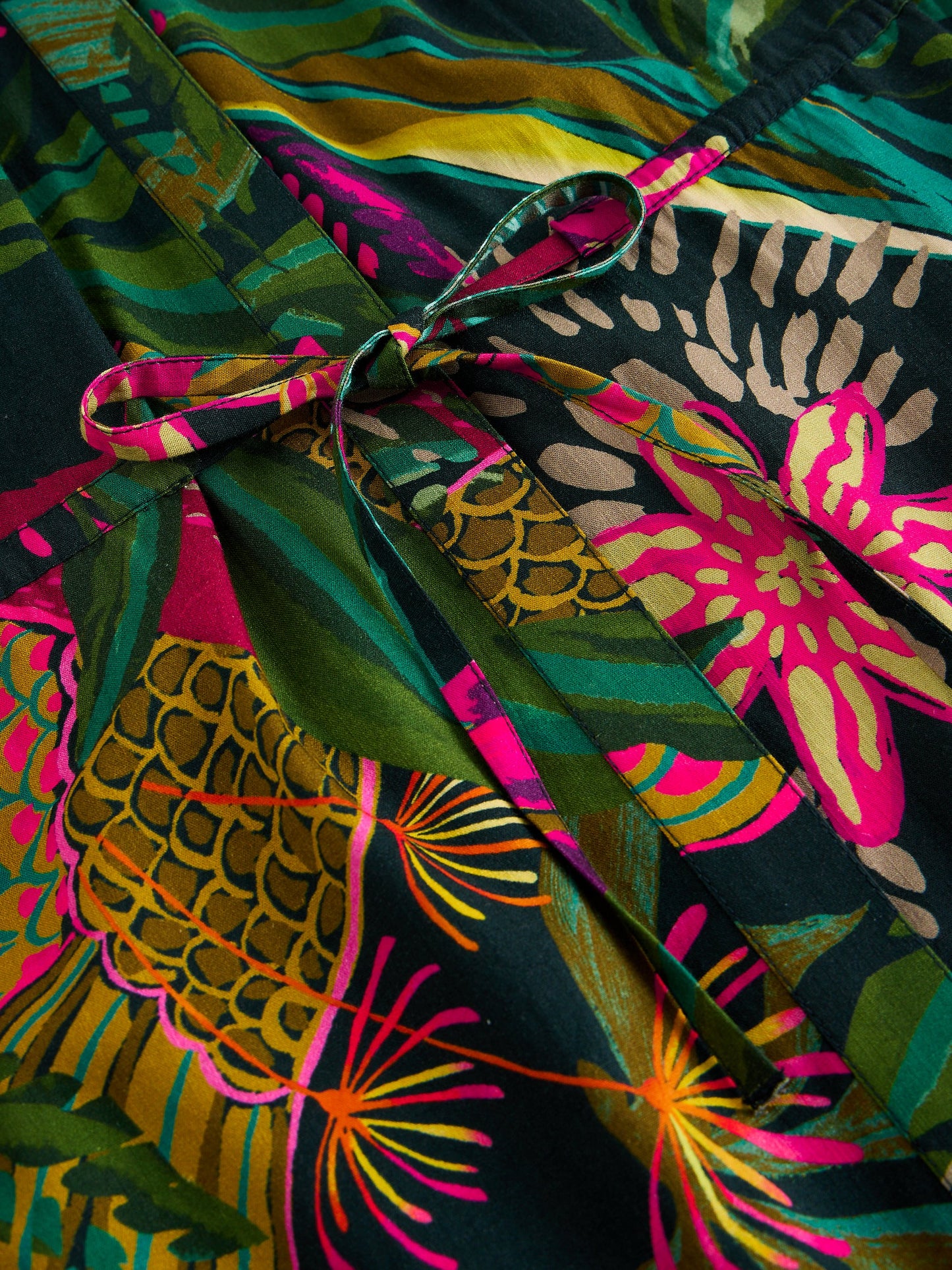 Colorful fabric with pineapple and floral patterns on a dark background