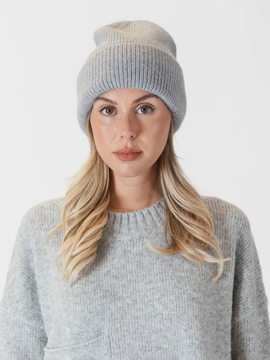 Meet the Apres Ski Hat by Lyla &amp; Luxe in light grey - your ultimate companion for embracing the après-ski vibe with a touch of pizzazz and coziness. Crafted from premium materials, this hat boasts a snug knit design that guarantees utmost comfort in frosty temperatures. lemon cyprus boutique