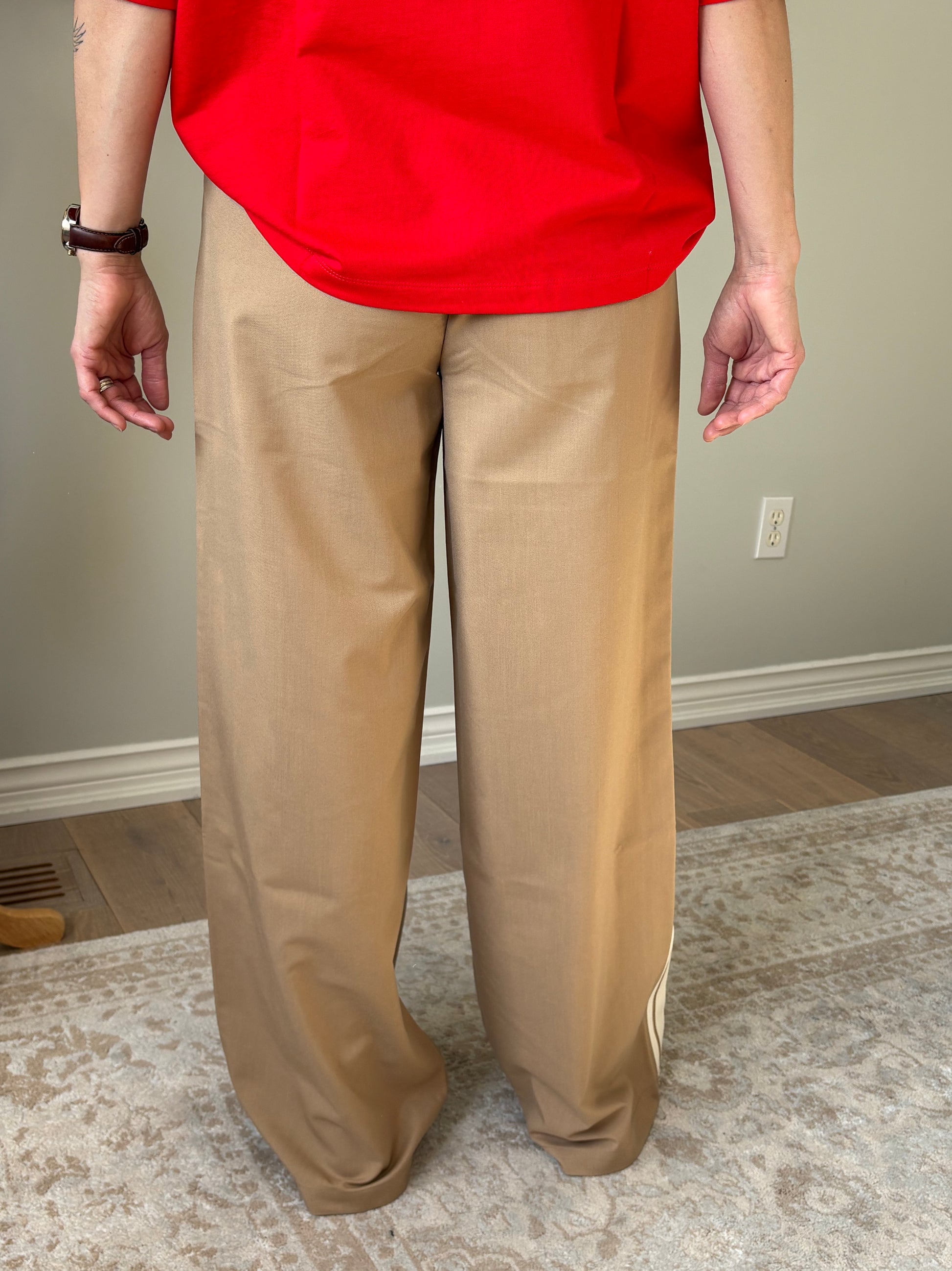 Person wearing beige pants and a red top indoors.