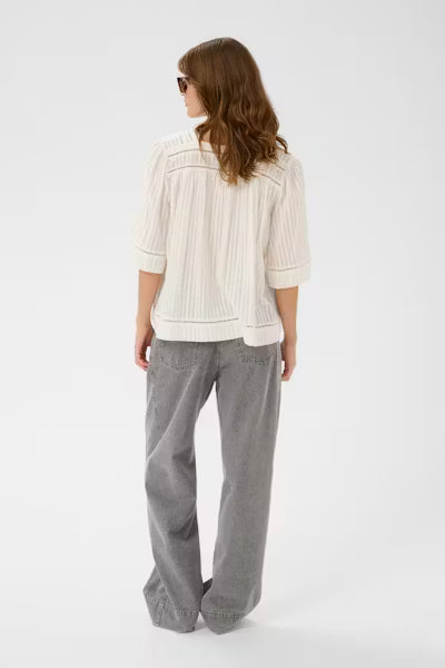 Woman wearing a white striped shirt and gray pants on a white background