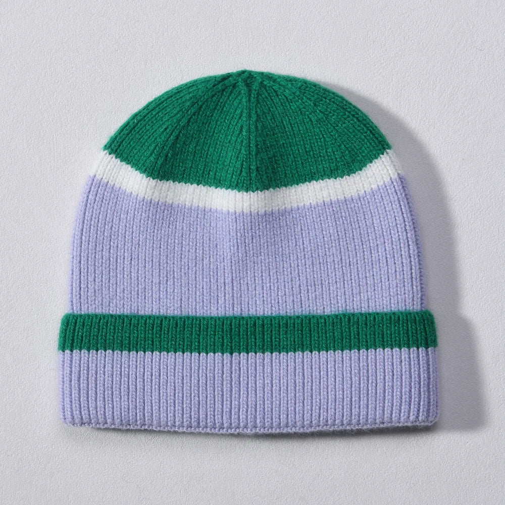 Green and lilac colour block cashmere-blend beanie with white stripe accent, laid flat on a light background.