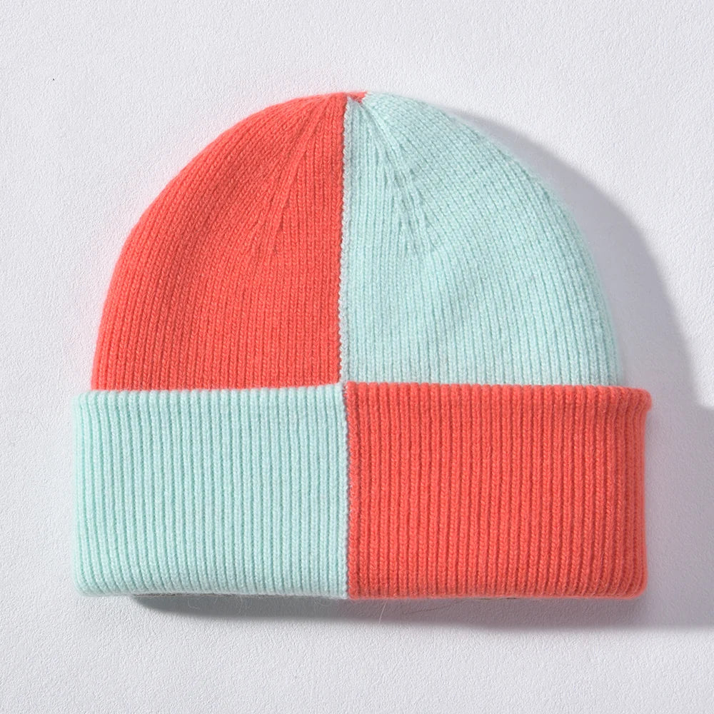 Mint and coral checkerboard colour block cashmere-blend beanie, laid flat on a light background.