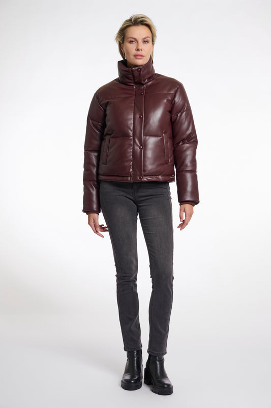 Person wearing a brown puffer jacket and black pants on a white background