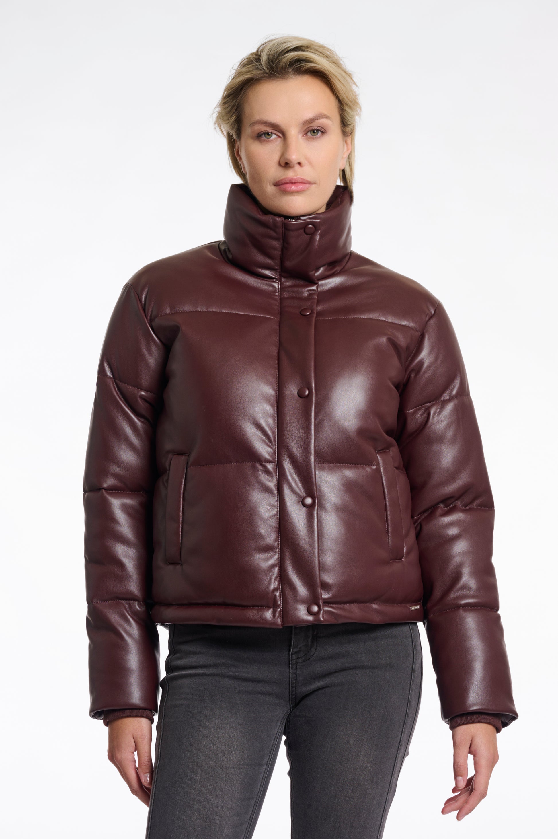 Person wearing a brown leather puffer jacket on a white background