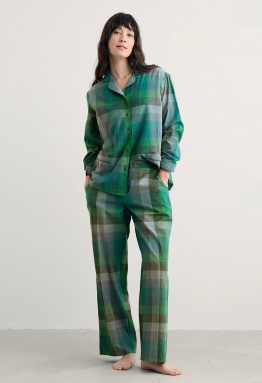 Person wearing green plaid pajamas on a white background