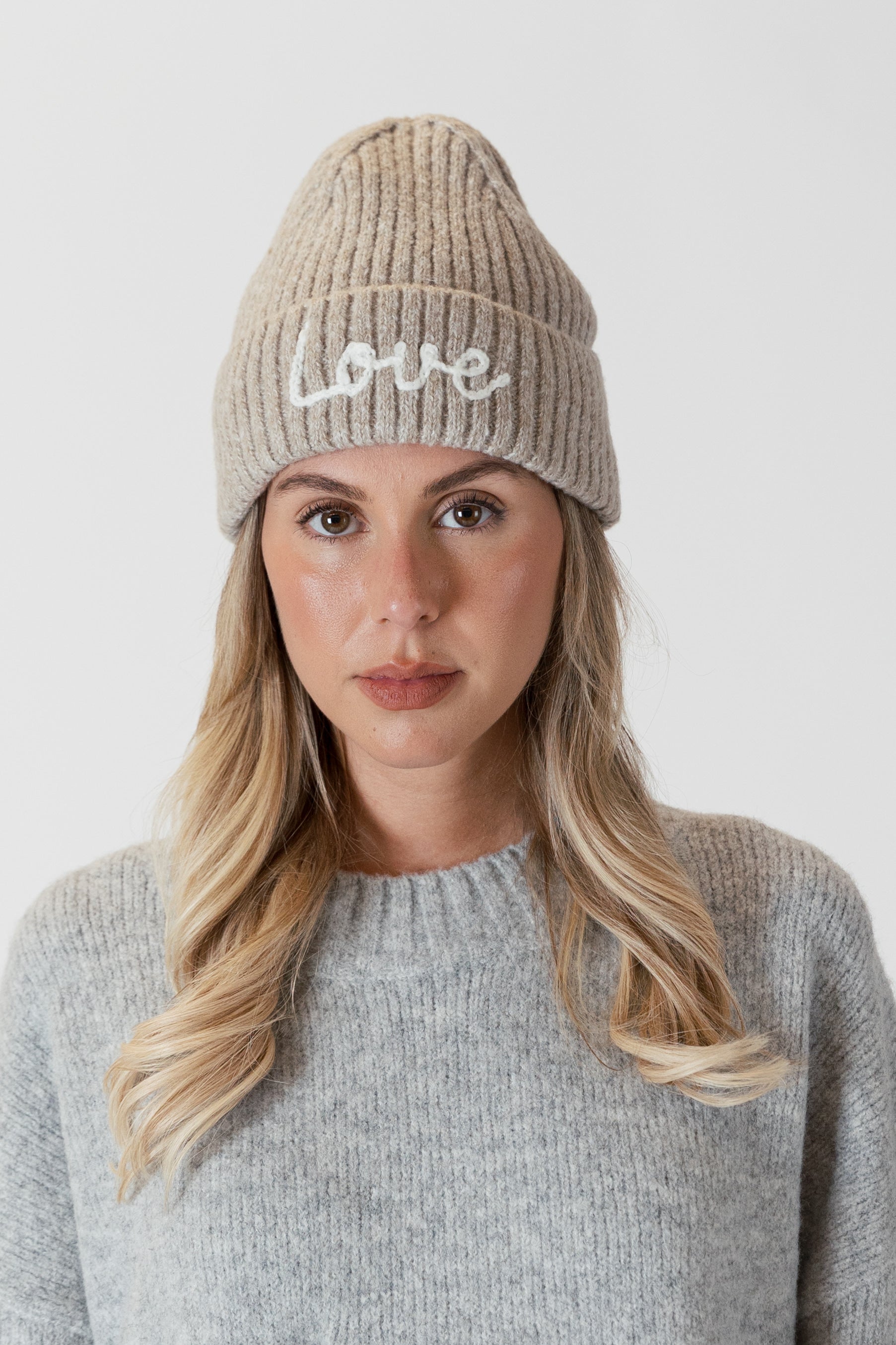 This cozy driftwood beanie by Lyla &amp; Luxe is adorned with intricate embroidery, featuring the word "love" stitched into the soft and warm ribbed knit fabric. Not only does it keep you warm, but it also spreads love and cheer as a stylish statement piece.