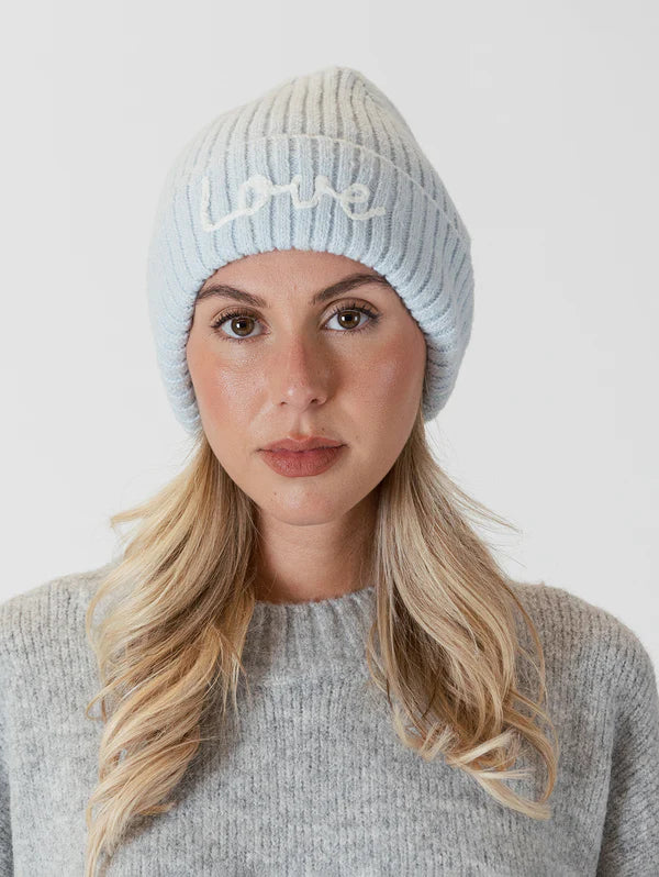 This cozy pastel blue beanie by Lyla &amp; Luxe is adorned with intricate embroidery, featuring the word "love" stitched into the soft and warm ribbed knit fabric. lemon cyprus boutique