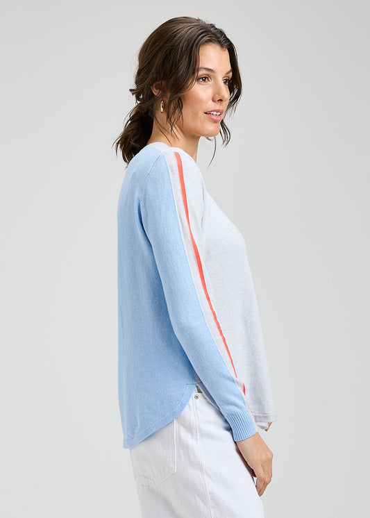 Woman wearing a light blue cardigan with a white background