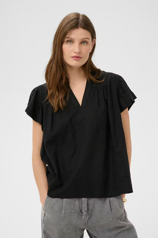 Woman wearing a black top and gray pants on a white background